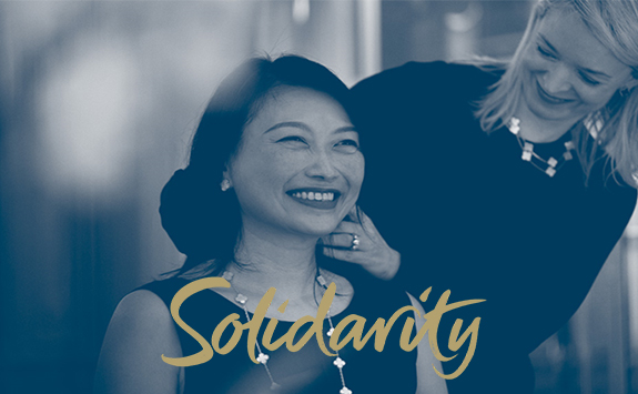 Image of two women smiling with an overlay text "solidarity"