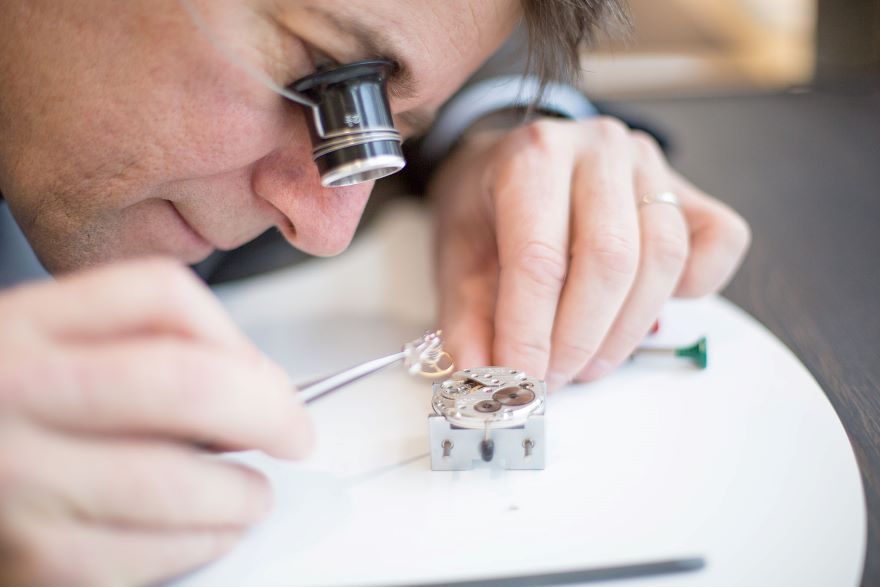 A watchmaker adding design elements to a mechanical watch