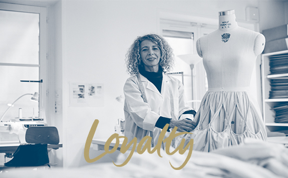 Image of a woman in a tailor's workshop with an overlay text "loyalty"