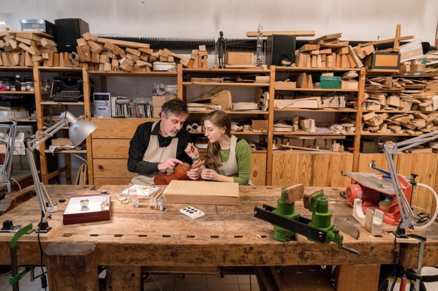 Two craftsmen working on a piece in a workshop